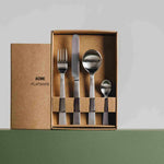 This image depicts Acme's brushed flatware set in sustainable cardboard packaging